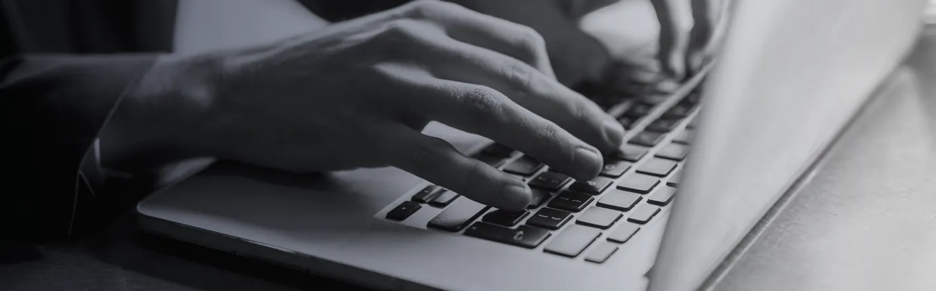 Black and white image of hands typing on a keyboard