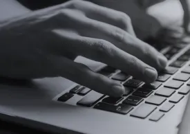 Black and white image of hands typing on a keyboard